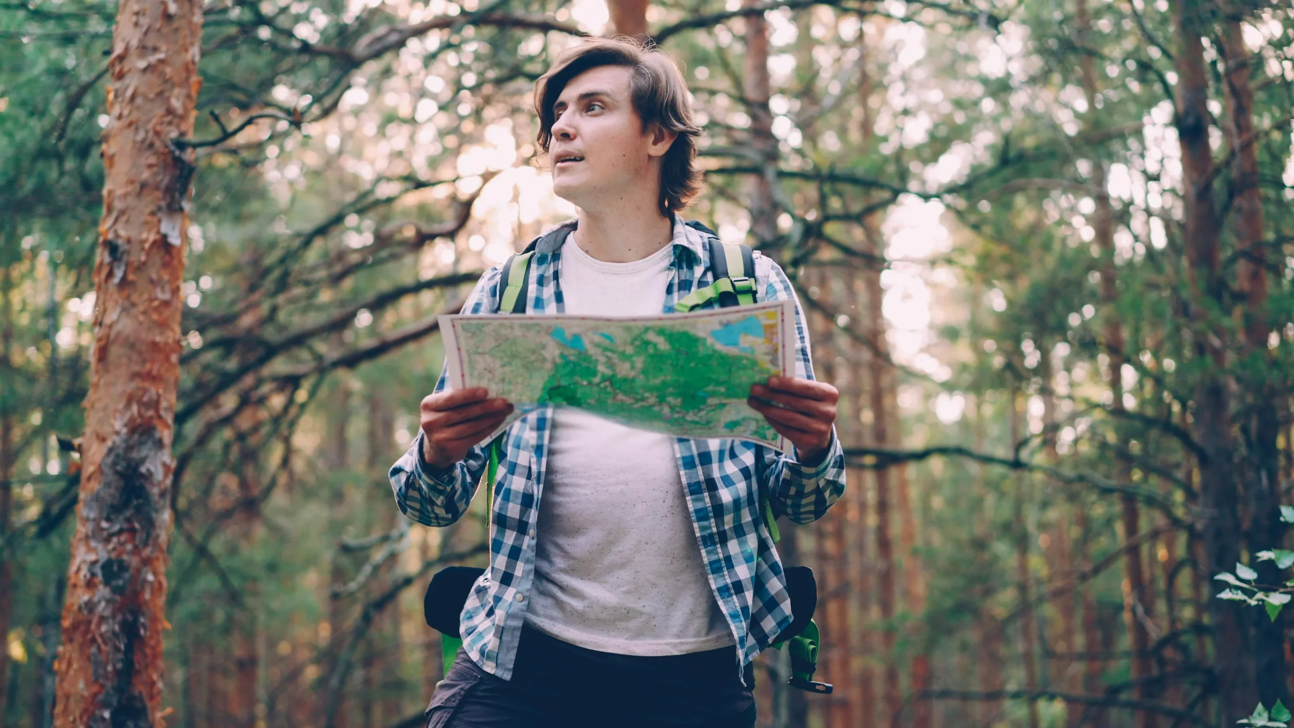 hiking planning habits showing a hiker checking weather and trail details before departure