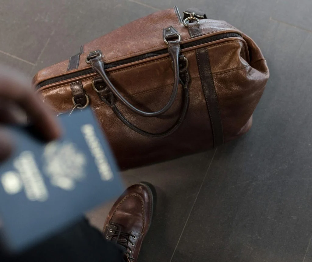 Solo traveler organizing passport, phone, and notebook with a day bag