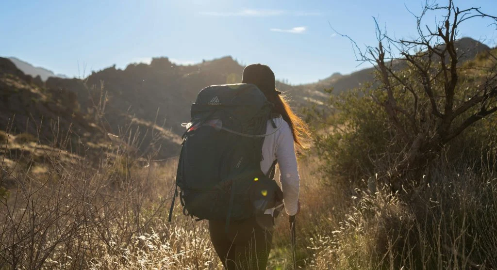 Hiker checking map and backpack before sunrise hike