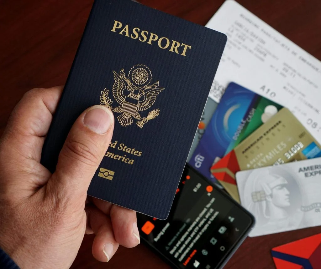 Traveler checking passport and boarding details with carry-on luggage