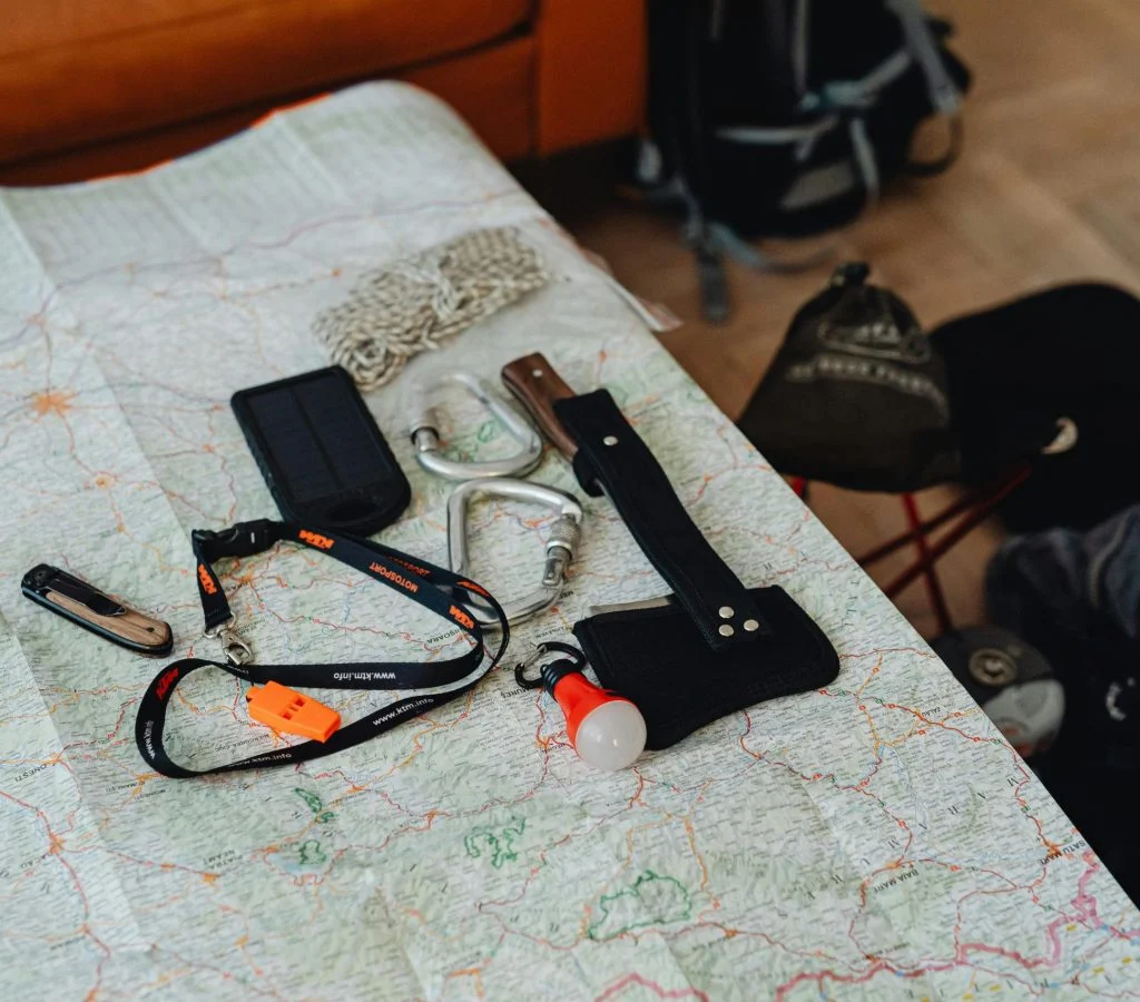 Hiker checking map, backpack, and weather before a day hike